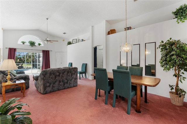 carpeted dining space featuring ceiling fan with notable chandelier and high vaulted ceiling