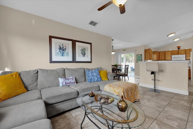 living room with ceiling fan, light tile patterned floors, and vaulted ceiling