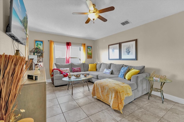 living room with light tile patterned floors, a textured ceiling, and ceiling fan