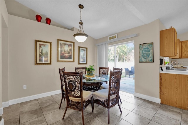 dining area featuring light tile patterned floors and vaulted ceiling