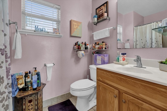 bathroom with tile patterned flooring, vanity, and toilet