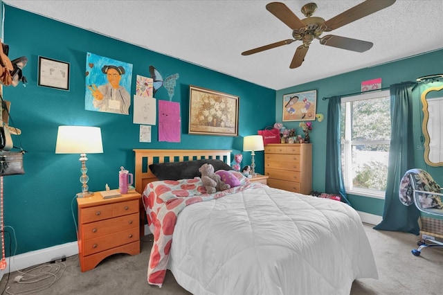 carpeted bedroom featuring ceiling fan and a textured ceiling