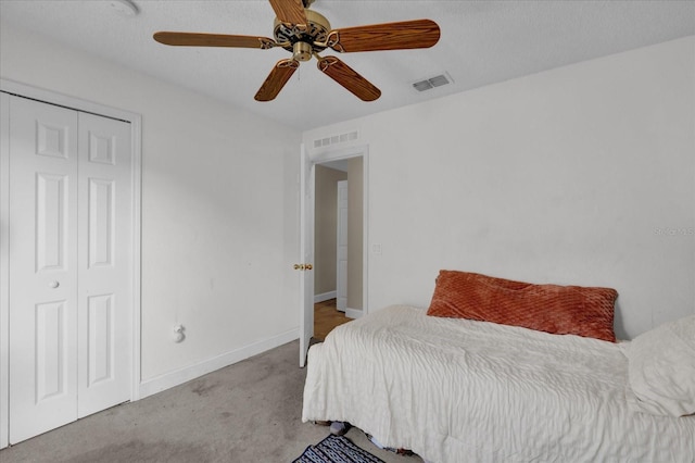 bedroom with ceiling fan, light colored carpet, and a closet