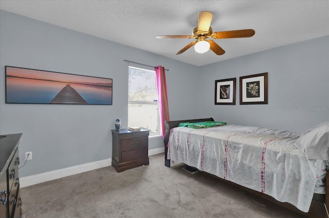 bedroom with a textured ceiling, ceiling fan, and light carpet