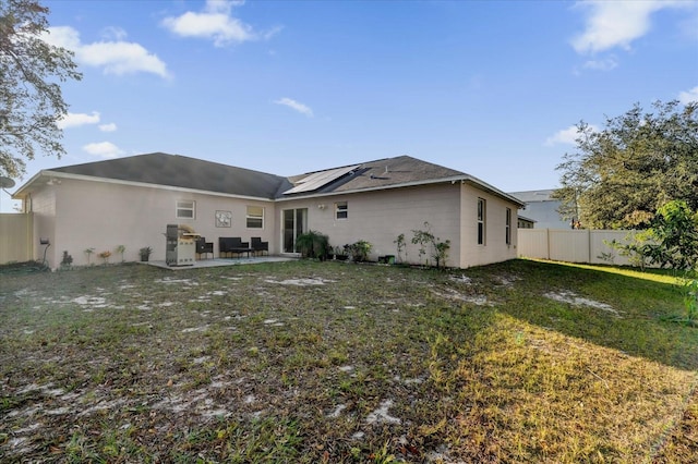 rear view of house with a lawn and a patio