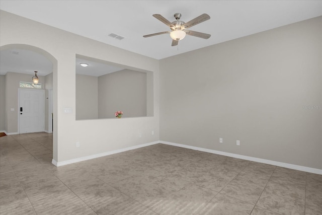 empty room with ceiling fan and light tile patterned floors