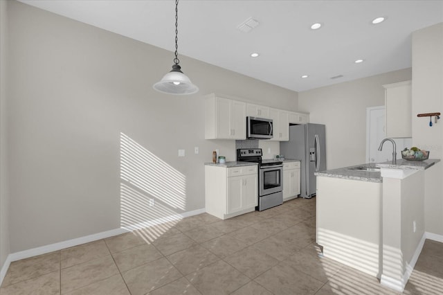 kitchen featuring appliances with stainless steel finishes, light tile patterned floors, light stone counters, white cabinetry, and decorative light fixtures