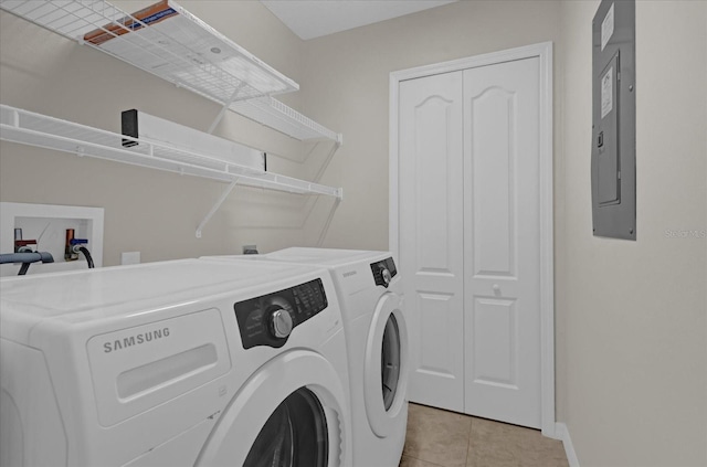 laundry area featuring washing machine and dryer, light tile patterned flooring, and electric panel