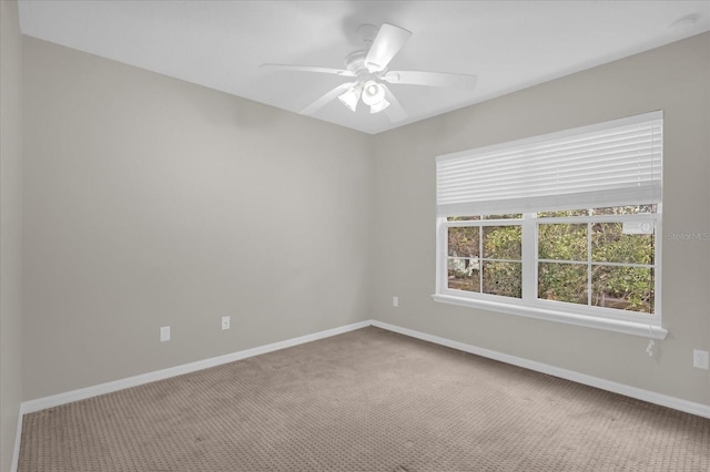 empty room with a ceiling fan, baseboards, and carpet floors