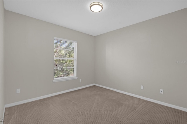 carpeted spare room with baseboards