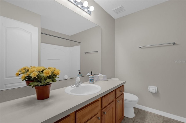 bathroom with toilet, tile patterned floors, and vanity