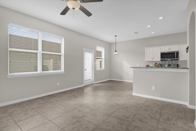 unfurnished living room featuring light tile patterned floors, recessed lighting, ceiling fan, and baseboards