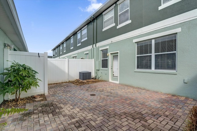 view of patio featuring central AC unit and fence