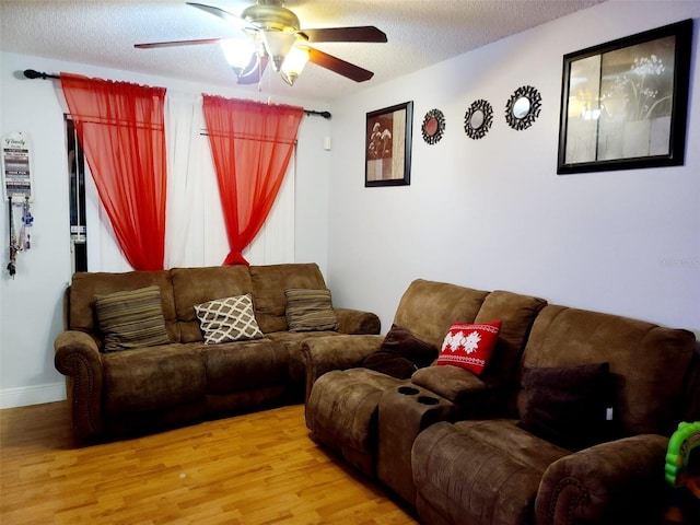 living room with hardwood / wood-style floors, ceiling fan, and a textured ceiling