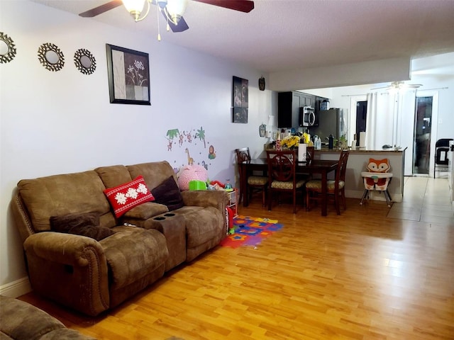 living room featuring ceiling fan and wood-type flooring