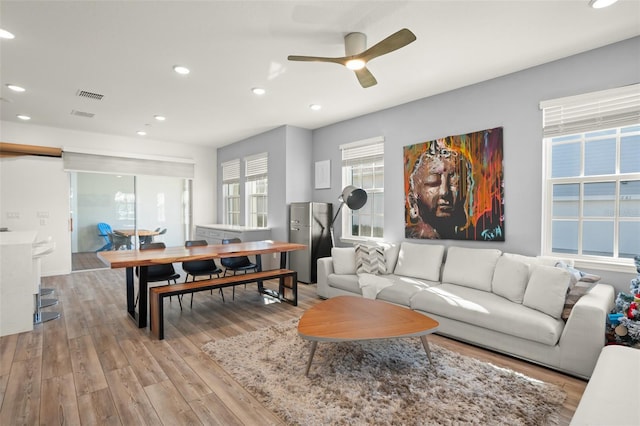 living room featuring light hardwood / wood-style floors and ceiling fan