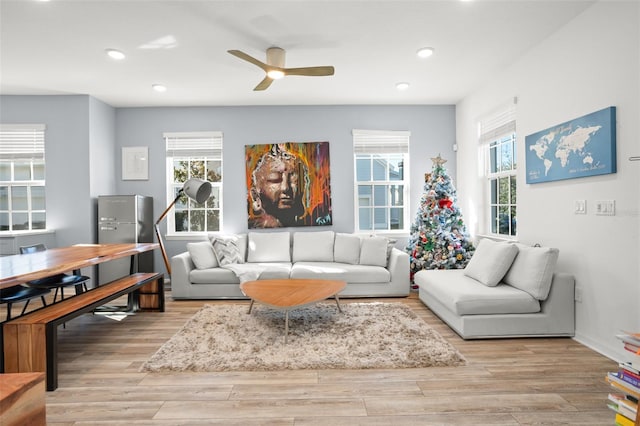 living room featuring ceiling fan, light hardwood / wood-style floors, and a wealth of natural light