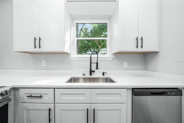 kitchen featuring white cabinetry, sink, stainless steel appliances, and light stone counters