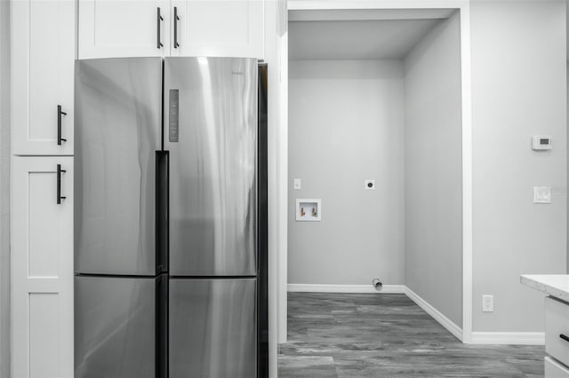 kitchen featuring stainless steel refrigerator, light stone counters, white cabinets, and dark hardwood / wood-style floors