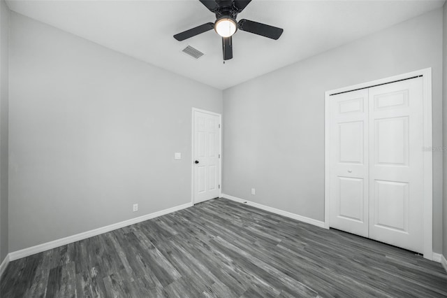 unfurnished bedroom featuring dark hardwood / wood-style flooring, a closet, and ceiling fan