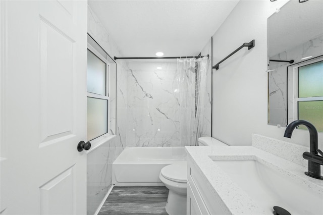 full bathroom with vanity, toilet, tiled shower / bath, and hardwood / wood-style flooring