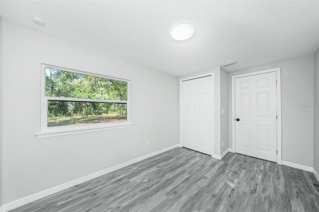 unfurnished bedroom with a closet, light hardwood / wood-style floors, and a textured ceiling