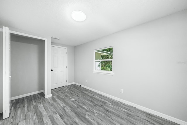 unfurnished bedroom with hardwood / wood-style flooring and a textured ceiling