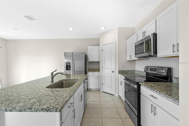 kitchen featuring stainless steel appliances, sink, light tile patterned floors, a center island with sink, and white cabinets