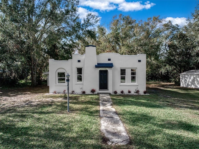 pueblo revival-style home featuring a front yard