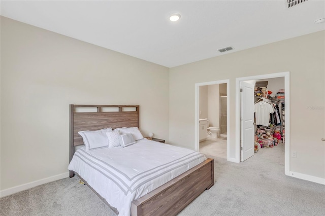 carpeted bedroom with ensuite bathroom, a spacious closet, and a closet