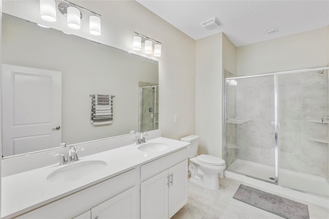 bathroom with tile patterned floors, vanity, toilet, and a shower with door