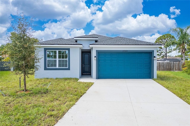 view of front of property featuring a front yard and a garage