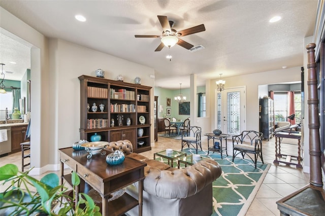 tiled living room with ceiling fan with notable chandelier, a textured ceiling, and sink