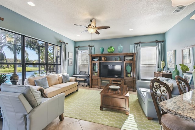 tiled living room featuring ceiling fan and a textured ceiling