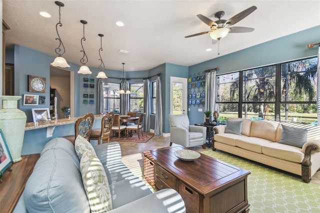 living room with ceiling fan, a healthy amount of sunlight, and a textured ceiling