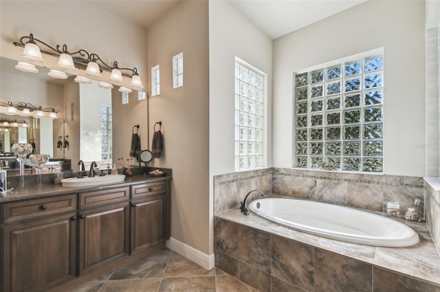 bathroom featuring tiled tub and vanity