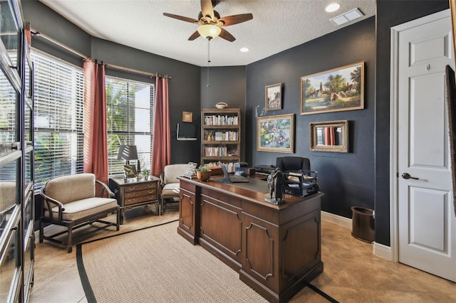 tiled office space with ceiling fan and a textured ceiling