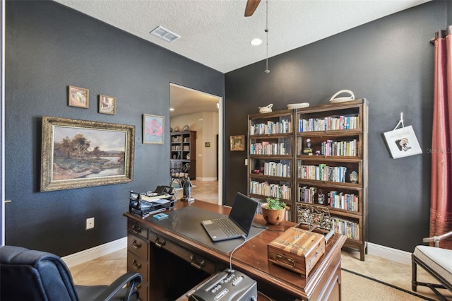 tiled home office with ceiling fan and a textured ceiling