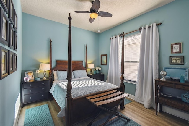 bedroom featuring ceiling fan, a textured ceiling, and hardwood / wood-style flooring