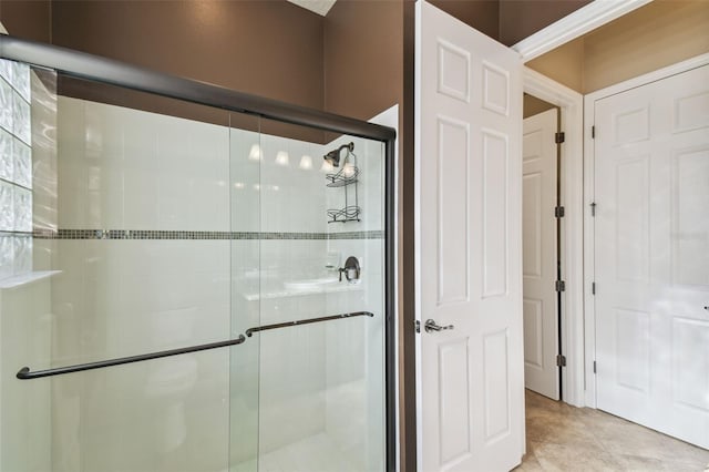 bathroom with tile patterned flooring and a shower with shower door