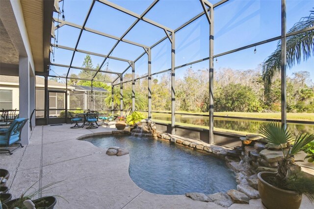 view of pool with pool water feature, glass enclosure, and a patio area