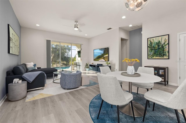 dining space with ceiling fan and light hardwood / wood-style flooring