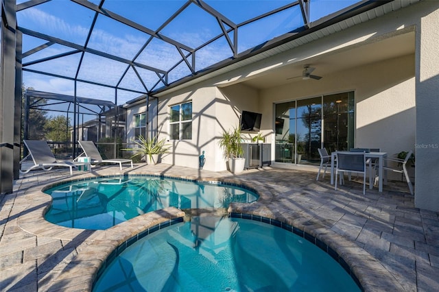 view of swimming pool featuring an in ground hot tub, a lanai, ceiling fan, and a patio area