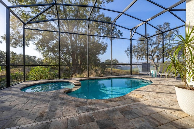 view of pool with glass enclosure, an in ground hot tub, and a patio