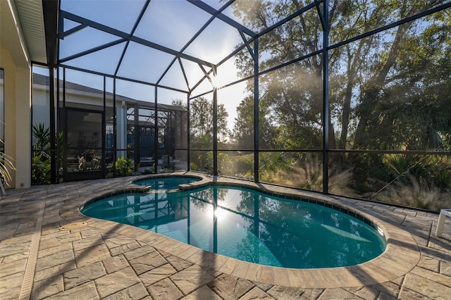 view of swimming pool with an in ground hot tub, glass enclosure, and a patio area