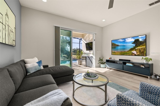 living room with ceiling fan and light hardwood / wood-style flooring