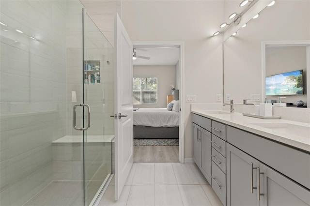 bathroom with tile patterned floors, ceiling fan, a shower with door, and vanity