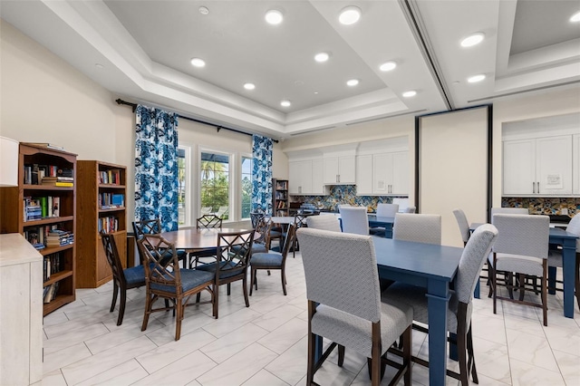 dining space with a raised ceiling