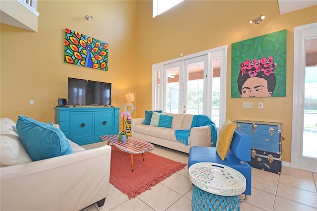 tiled living room featuring french doors and a towering ceiling