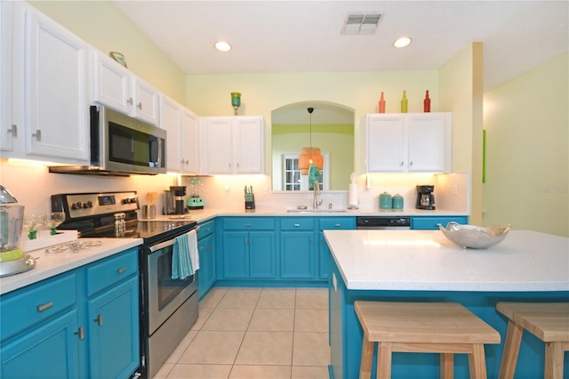 kitchen featuring decorative light fixtures, white cabinetry, sink, and appliances with stainless steel finishes